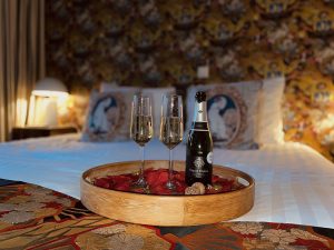 Cava in glazen op bed met rozenblaadjes bij hotel Goud en Zilver
