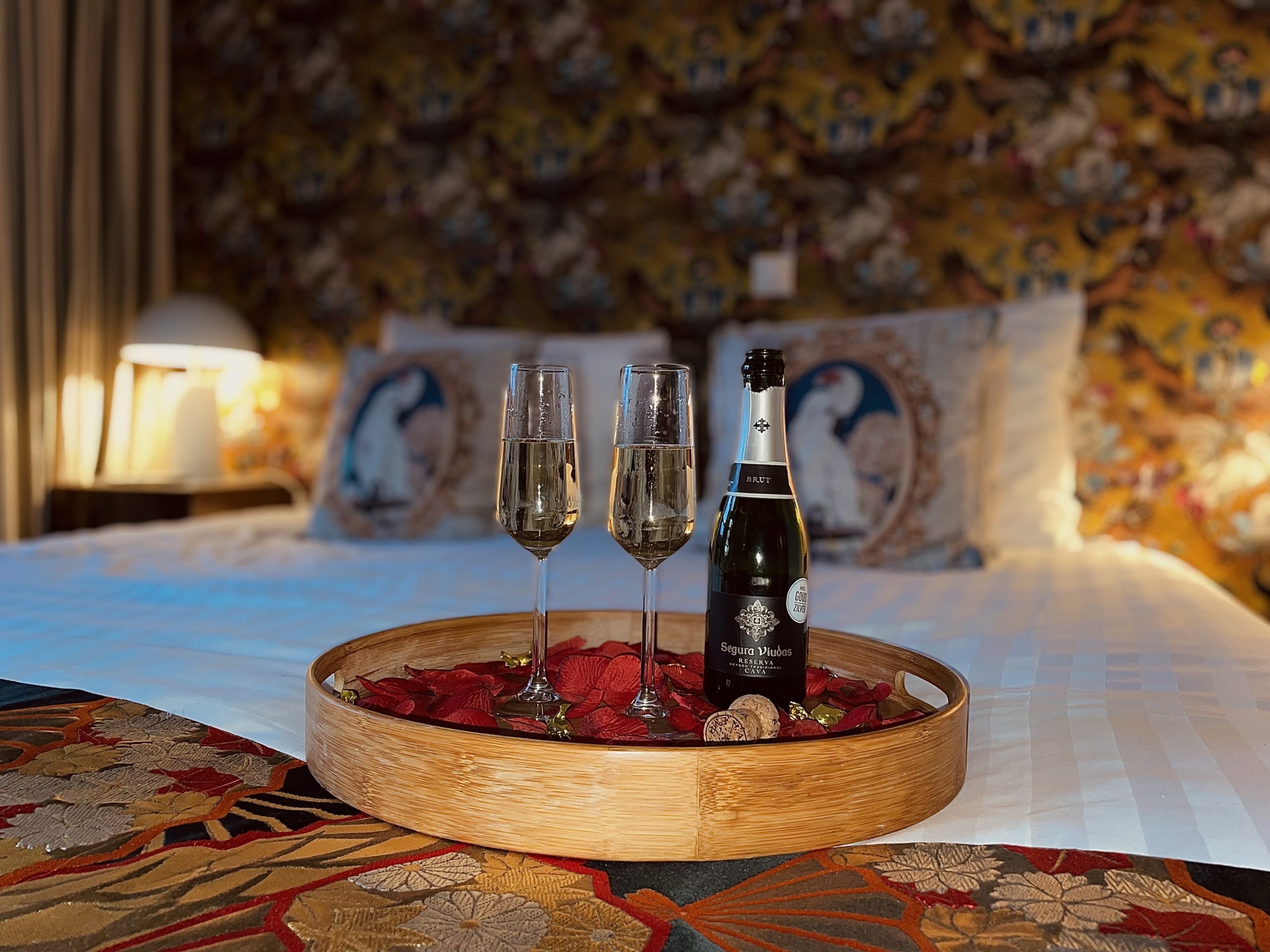 Cava in glazen op bed met rozenblaadjes bij hotel Goud en Zilver